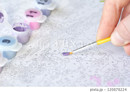 Hand painting by numbers with small brush and purple paint for relaxation Hand painting by numbers with small brush and purple paint for relaxation 120878224