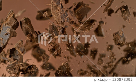 Freeze motion of flying group of raw chocolate pieces. 120878393