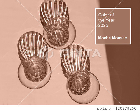 Mocha Mousse - color of year 2025. Abstract Light and Shadow from drinking glasses on light Surface Mocha Mousse - color of year 2025. Abstract Light and Shadow from drinking glasses on light Surface 120879250