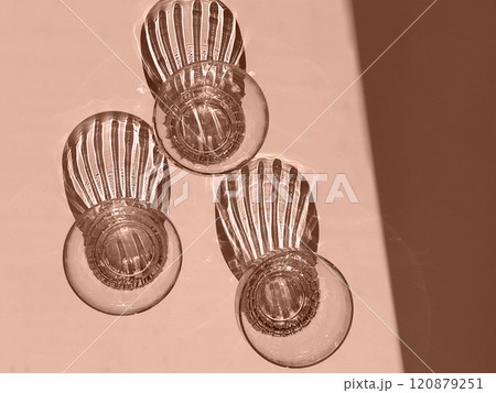 Mocha Mousse - color of the year 2025. Abstract Light and Shadow from drinking glasses on White Surface 120879251