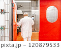 Butcher opening red door in food processing plant 120879533