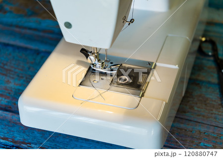 Detail of the needle, foot and presser foot of a household sewing machine. 120880747
