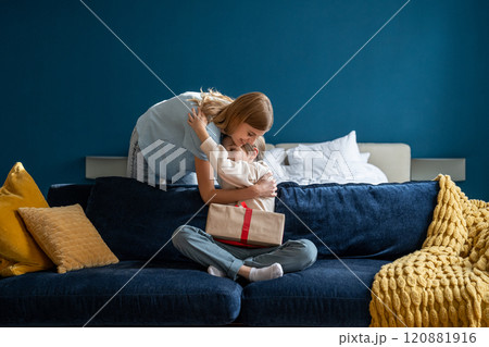 Young loving mother hugging happy little boy son while celebrating his birthday together at home 120881916