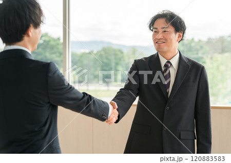 握手をする中年ビジネスマン（ロビー活動・ロビーイング・挨拶・契約・協定・合意） 120883583
