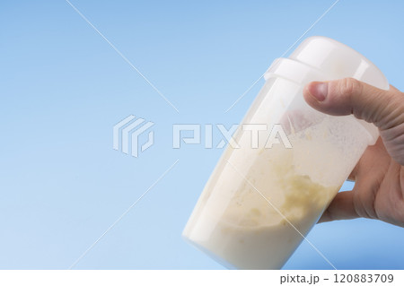 シェイカーを使ってプロテインドリンクを作る手元 120883709