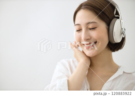ヘッドフォンで音楽を聴く若い女性 120883922