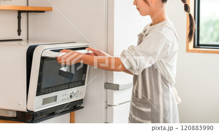 家のキッチンで電子レンジを使う子供・女の子（小学生・中学生） 120883990