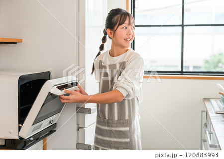 家のキッチンで電子レンジを使う子供・女の子（小学生・中学生） 120883993
