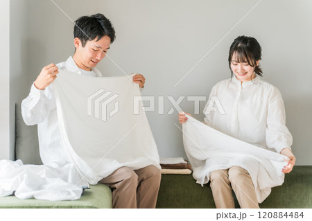 洗濯物の仕上がりに満足な若い夫婦(柔軟剤・タオル・部屋干し) 洗濯物の仕上がりに満足な若い夫婦(柔軟剤・タオル・部屋干し) 120884484
