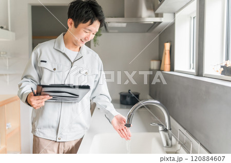 水道をチェックする水道屋・設備会社・リフォーム業者・工務店の作業服姿のビジネスマン 120884607