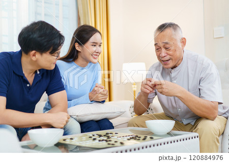 Happy cheerful Asian family spending time to play Go Game together in weekend. Daughter and son enjoy are playing board game with their father. Family's activities with senior elder adult. 120884976