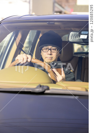 ながら運転のイメージ（スマホを注視する男性） 120885295