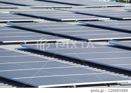 Arerial view showing a solar panels array on factory - warehouse rooftop close up. Solar cell array installed on the building rooftop, renewable and sustainable energy concept. Arerial view showing a solar panels array on factory - warehouse rooftop close up. Solar cell array installed on the building rooftop, renewable and sustainable energy concept. 120885989