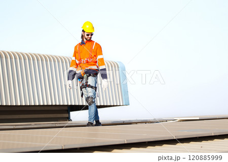Professional electric engineers survey and inspect solar panels installation on the factory metal sheet roof top, electric engineer team inspecting and check solar cell system. 120885999