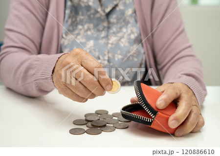 Asian senior or elderly old lady woman holding counting coin money in bag. Poverty, saving problem in retirement. Asian senior or elderly old lady woman holding counting coin money in bag. Poverty, saving problem in retirement. 120886610