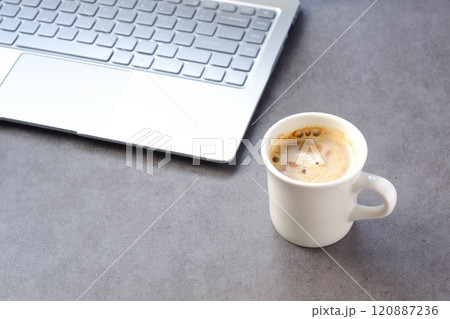美味しいコーヒーを飲みながら、ノートパソコンでデスクワークをしているイメージ 120887236