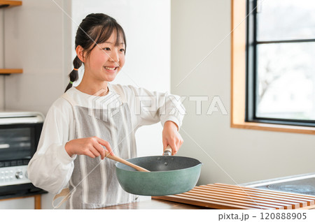 家のキッチンで料理を作る子供(小学生・中学生・高校生・女の子) 家のキッチンで料理を作る子供(小学生・中学生・高校生・女の子) 120888905