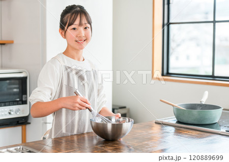 家のキッチンでお菓子作りを楽しむ子供（小学生・中学生・高校生・女の子） 120889699