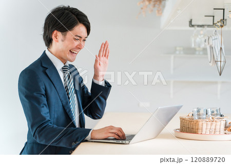 ノートパソコンを使いオンライン通話する若いアジア人ビジネスマン ノートパソコンを使いオンライン通話する若いアジア人ビジネスマン 120889720