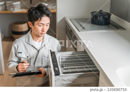 キッチンの食洗機・食器洗い乾燥機を診断・チェック・査定する作業服姿の男性ビジネスマン キッチンの食洗機・食器洗い乾燥機を診断・チェック・査定する作業服姿の男性ビジネスマン 120890750