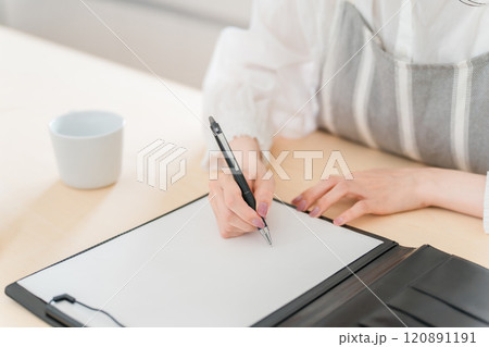 契約書・同意書にサインする主婦・女性の手元 120891191