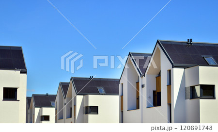 Terraced family homes in newly developed housing estate. The real estate market in the suburbs. New single family houses in a new development area. Residential homes with modern facade.  120891748