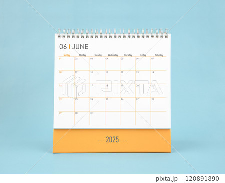 June 2025 white desk calendar on blue color background. 120891890