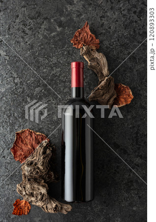 Bottle of red wine on a black stone background. 120893303