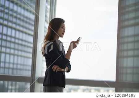 young asian businesswomen looking at mobile phone in modern office 120894195
