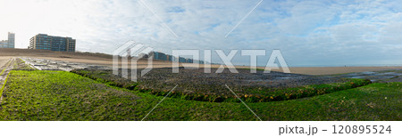 Scenic Coastal View with Buildings and Lush Green Foreground 120895524