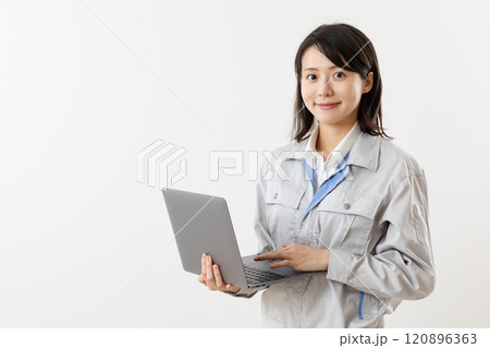 PCを操作する作業服を着た女性01 120896363