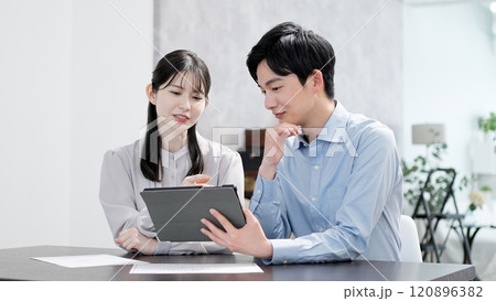 タブレットで資料を見る男女 120896382