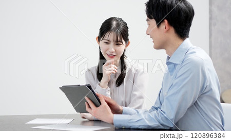タブレットで資料を見る男女 120896384