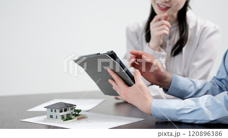 タブレットで不動産の情報を見る男女 タブレットで不動産の情報を見る男女 120896386