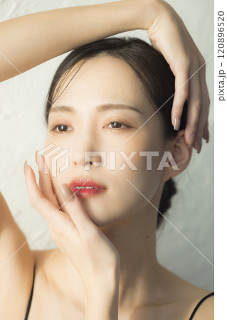 顔に手を当てる若い女性 120896520