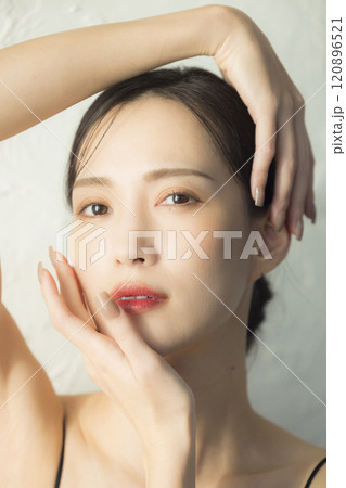 顔に手を当てる若い女性 120896521