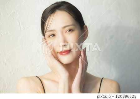 顔に手を当てる若い女性 120896528
