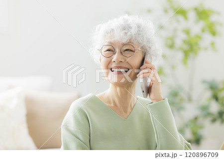 リビングで電話するシニア女性　 120896709