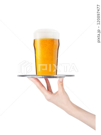Hand holds tray with lager beer glass with bubbles 120897477