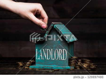 Wooden house model with coins next to it and hand Wooden house model with coins next to it and hand 120897480