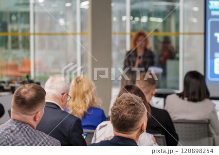 Audience attentively listens to presentation in modern conference room 120898254