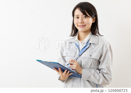 笑顔でメモをする作業着の女性01 120898725