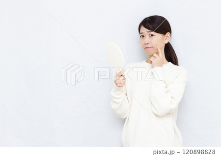 お肌をチェックするミドル女性 120898828