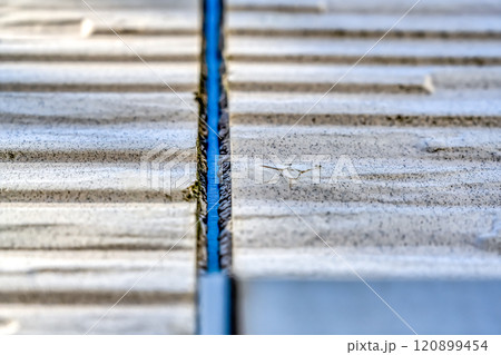 劣化したシーリング材とサイディング 120899454