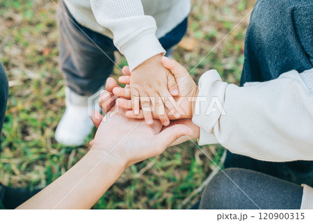 手を重ねる3人の親子 120900315