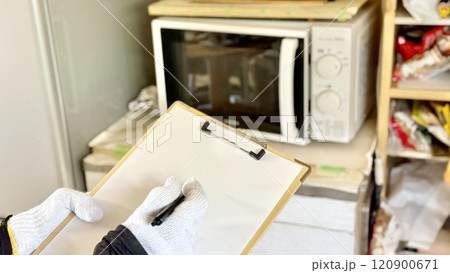 電子レンジ前でクリップボードに記入する軍手をはめた手 電子レンジ前でクリップボードに記入する軍手をはめた手 120900671