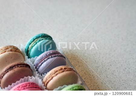 Bright colorful cakes French Macarons with white paperpan in plastic box 120900681