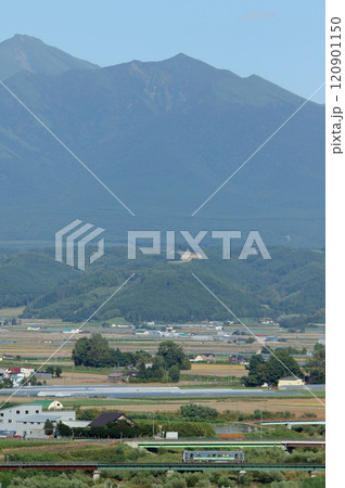 十勝岳連山をバックに駆ける富良野線普通列車 H100 DECMO 十勝岳連山をバックに駆ける富良野線普通列車 H100 DECMO 120901150