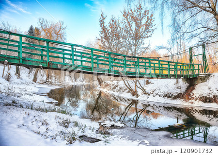 Breathtaking landscape in city park with snowy trees and beautiful reflection in frozen river. 120901732
