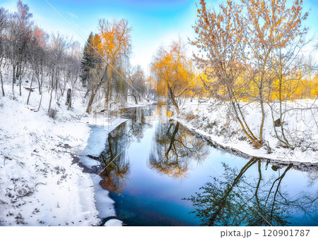 Breathtaking landscape in city park with snowy trees and beautiful reflection in frozen river. Breathtaking landscape in city park with snowy trees and beautiful reflection in frozen river. 120901787